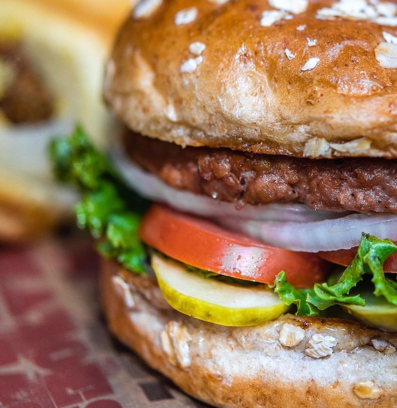 Epic Burger beyond vegetarian burger with tomatoes onion lettuce mustard and ketchup